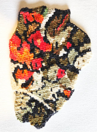 Blob-shaped tapestry woven with red, orange, brown and cream threads.