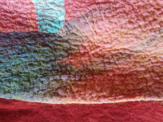 Felted artwork made from red and light blue felt.