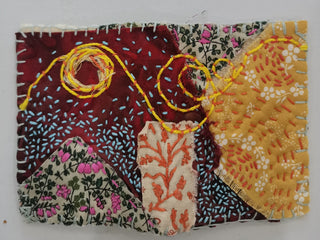 A textile collage artwork made from different patterned and coloured fabrics stitched together.