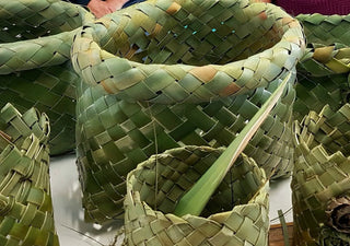 Green baskets of varying sizes woven from NZ flax or harakeke.