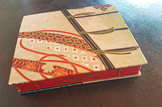 A book with a red spine and Japanese-inspired red and yellow patterned cover.