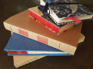 Books bound in different covers with unique colours and patterns.