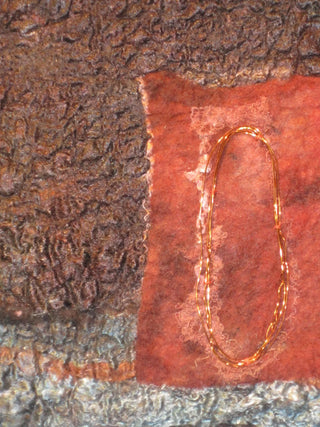 Close-up of detailing on red, brown and grey felt artwork, with gold wire accents.
