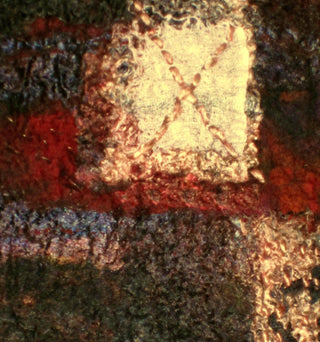 Close-up of white, red and brown detail on a felt artwork.