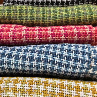 Hand loom woven washcloths and dishcloths in a grid pattern, in blue, red, black, yellow and green colours.