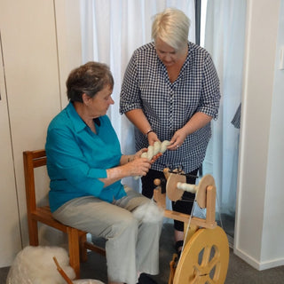 Spinning tutor Anne Grassham helping a student with their spinning during a workshop.