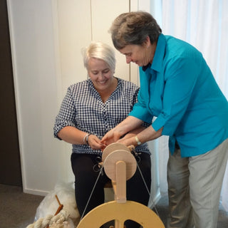 Spinning tutor Anne Grassham helping a student with their spinning during a workshop.
