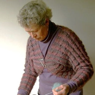 A student spins wool into yarn.