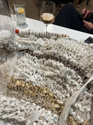 A tear in blue fabric is mended with a Speedweve darning loom, using rainbow threads.