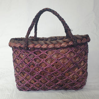 Back view of a traditional Māori Kete basket woven with purple brown Harakeke (NZ Flax).