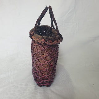 Side view of a traditional Māori Kete basket woven with purple brown Harakeke (NZ Flax).