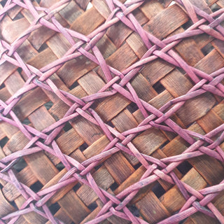 Close-up of the traditional Māori Kete basket woven with purple brown Harakeke (NZ Flax), showcasing it's intricate pattern.