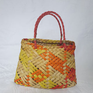 Back-view of a traditional Māori Kete basket woven with light brown, red, orange and yellow Harakeke (NZ Flax).