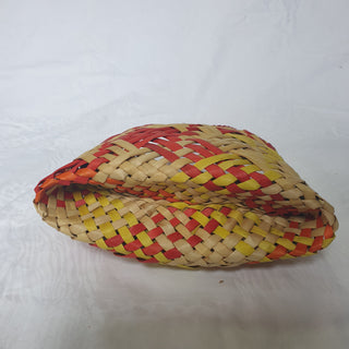 Bottom-view of a traditional Māori Kete basket woven with light brown, red, orange and yellow Harakeke (NZ Flax).