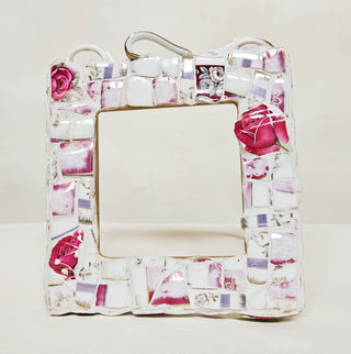 Square mosaic piece featuring broken handles of tea cups, and a pink and white floral pattern.