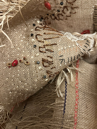 A student project of a coffee sack embellished with beading and thread, from their Next Level Coffee Sacks workshop.