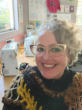 Tutor Renée Clothier smiles while taking a selfie in front her sewing machine.