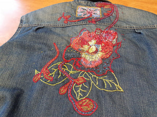 A embroidered flower pattern on some thrifted clothing, completed during the Embellish Me workshop.