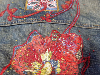 A embroidered flower pattern on some thrifted clothing, completed during the Embellish Me workshop.